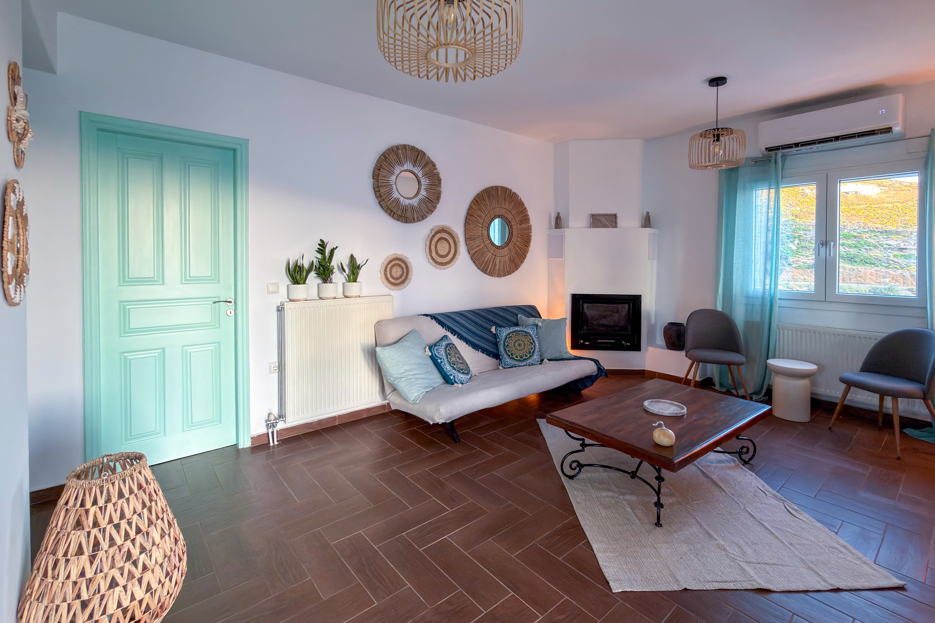 Living room with mint-green door and rattan wall decor